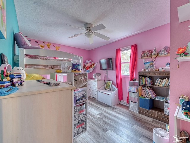 bedroom featuring light wood-type flooring, ceiling fan, and a textured ceiling