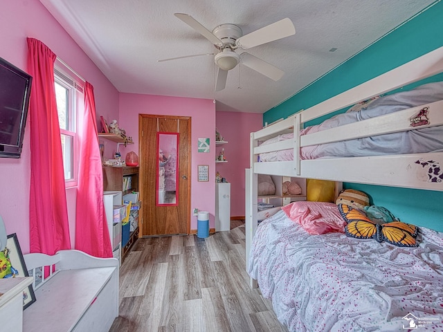 bedroom with a textured ceiling, wood finished floors, and ceiling fan