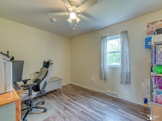 office area with a ceiling fan, baseboards, visible vents, and wood finished floors