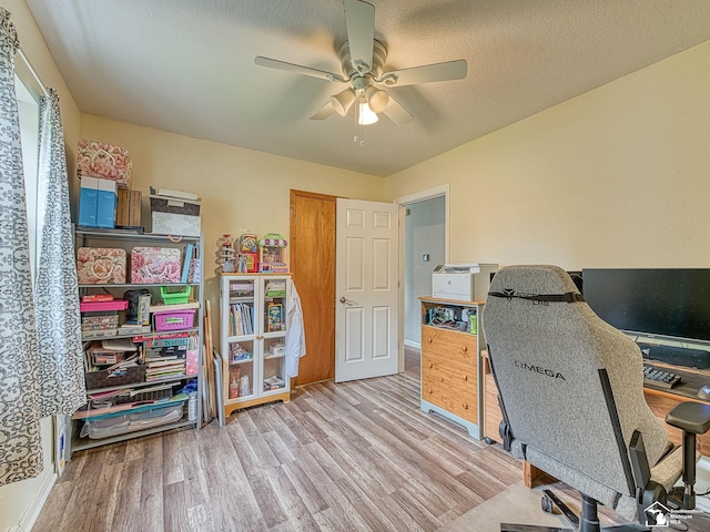 home office with a textured ceiling, wood finished floors, baseboards, and ceiling fan