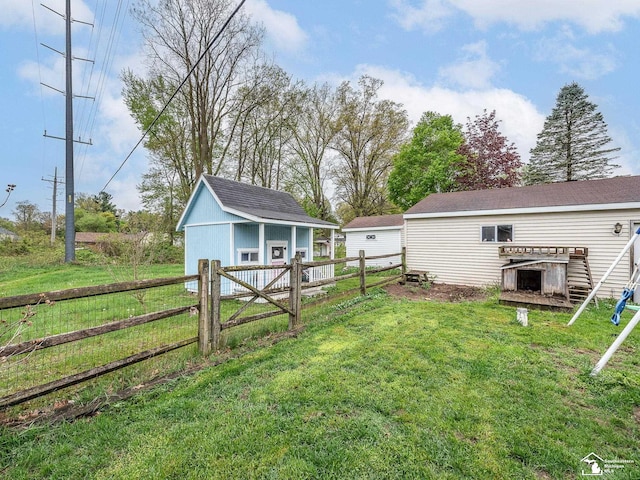 view of yard with a shed, fence, and an outdoor structure