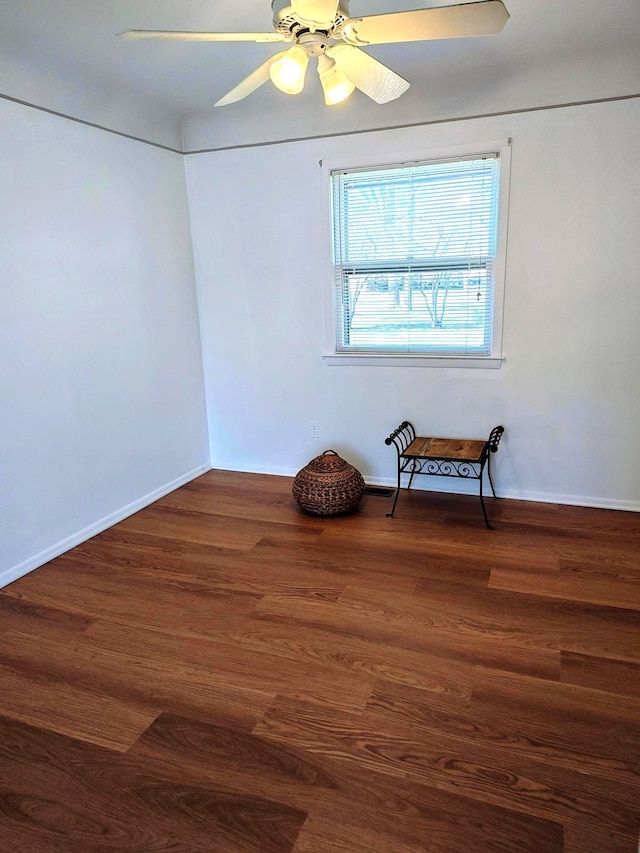 unfurnished room featuring baseboards, a ceiling fan, and wood finished floors
