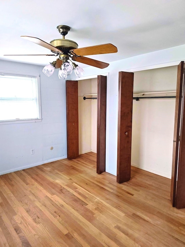 3385 Muerknoll Dr, Troy, MI 48084 - unfurnished bedroom with two closets, light wood-type flooring, a ceiling fan, and baseboards