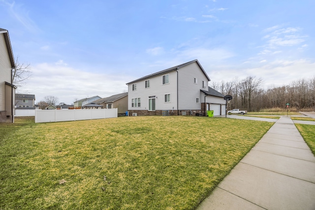 view of home's exterior featuring concrete driveway, a garage, fence, and a lawn