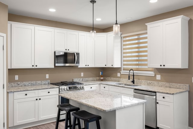 kitchen with stainless steel appliances, white cabinets, and a sink