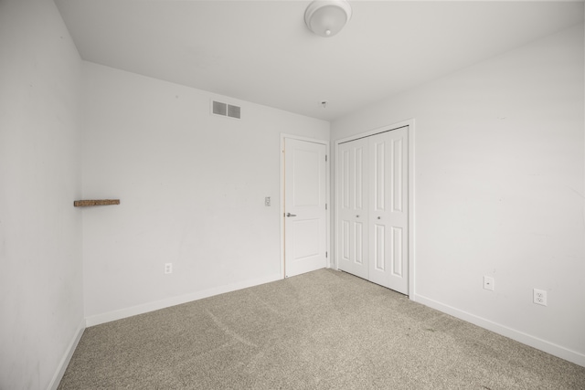 unfurnished bedroom featuring carpet, baseboards, a closet, and visible vents