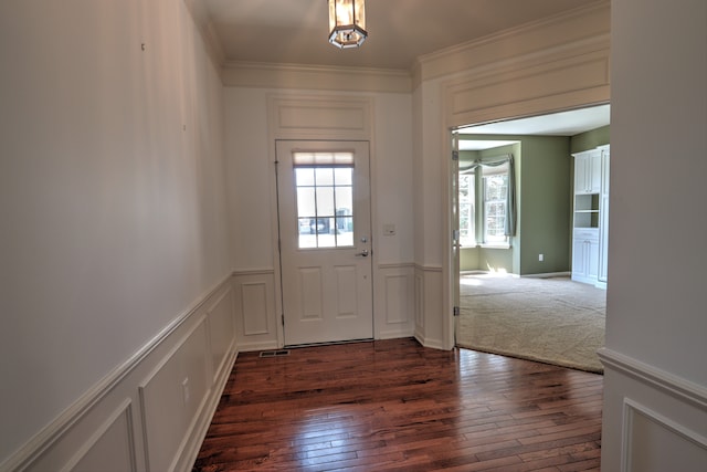 24179 Charlevoix St, Flat Rock, MI 48134 - foyer with healthy amount of natural light, dark wood-style flooring, ornamental molding, a wainscoted wall, and a decorative wall