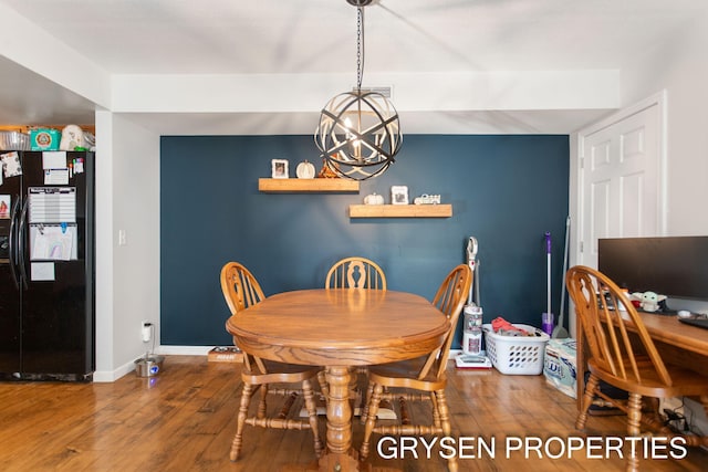 dining room featuring baseboards, a notable chandelier, and wood finished floors