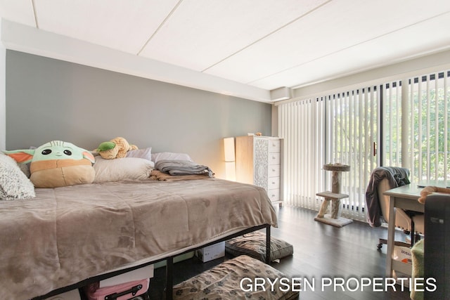 bedroom with multiple windows, access to exterior, and wood finished floors