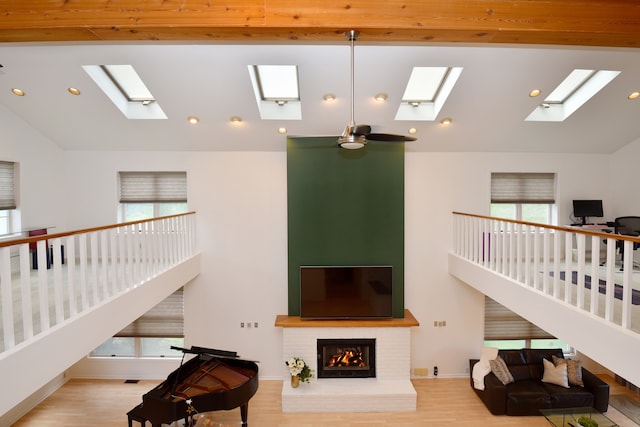 5100 Kings Gate Way, Bloomfield Hills, MI 48302 - living area featuring a skylight, lofted ceiling, wood finished floors, recessed lighting, and a brick fireplace