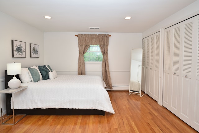 5100 Kings Gate Way, Bloomfield Hills, MI 48302 - bedroom featuring two closets, light wood finished floors, recessed lighting, and a baseboard heating unit