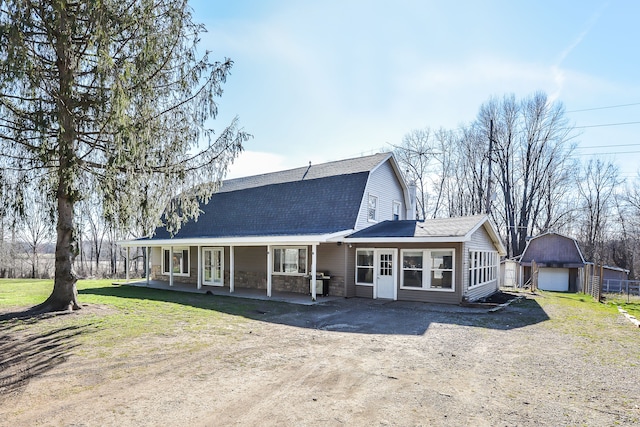 4780 Dutcher Rd, Howell, MI 48843 - view of front of property with a gambrel roof, dirt driveway, an outdoor structure, a porch, and roof with shingles