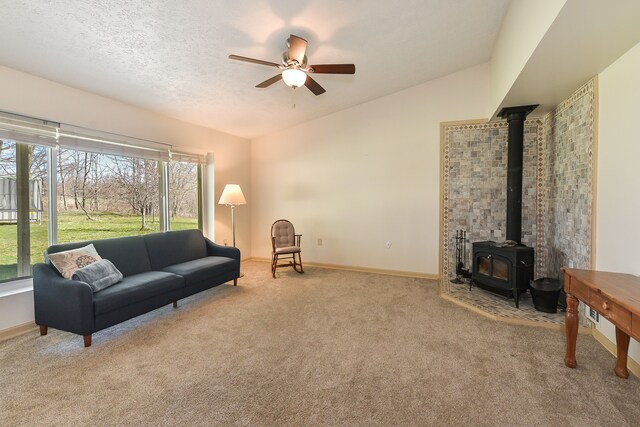 4780 Dutcher Rd, Howell, MI 48843 - carpeted living area with vaulted ceiling, a wood stove, baseboards, and a ceiling fan