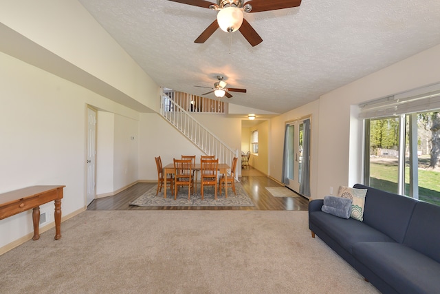 4780 Dutcher Rd, Howell, MI 48843 - carpeted dining room with stairs, wood finished floors, a textured ceiling, a ceiling fan, and baseboards