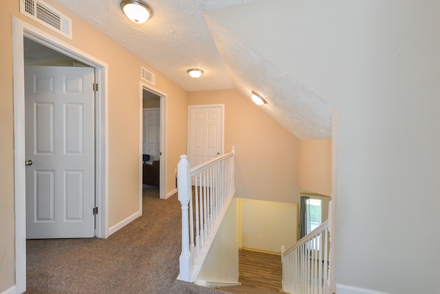 4780 Dutcher Rd, Howell, MI 48843 - hallway featuring baseboards, an upstairs landing, visible vents, and vaulted ceiling