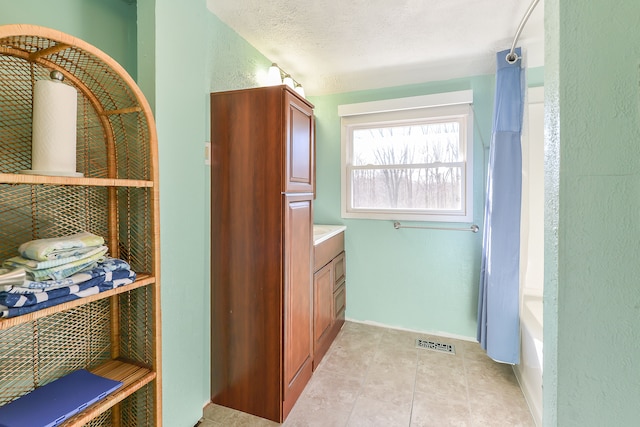 4780 Dutcher Rd, Howell, MI 48843 - full bathroom with baseboards, tile patterned floors, vanity, and visible vents