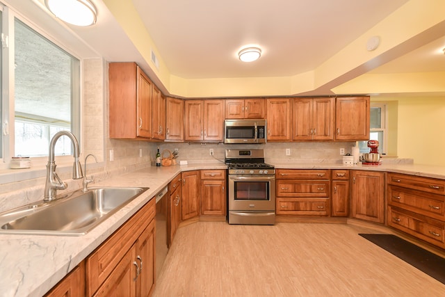 4780 Dutcher Rd, Howell, MI 48843 - kitchen featuring a sink, brown cabinetry, and stainless steel appliances