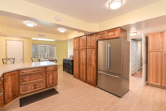 4780 Dutcher Rd, Howell, MI 48843 - kitchen with freestanding refrigerator, light countertops, visible vents, and brown cabinets