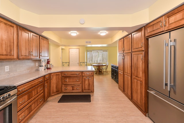 4780 Dutcher Rd, Howell, MI 48843 - kitchen featuring brown cabinets, a peninsula, and appliances with stainless steel finishes