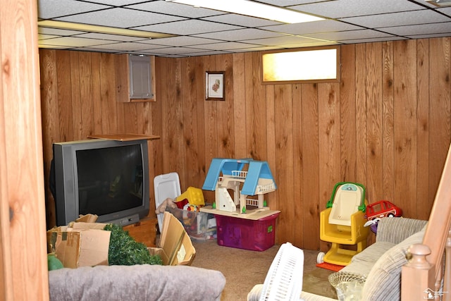 game room with a paneled ceiling, wooden walls, and carpet floors