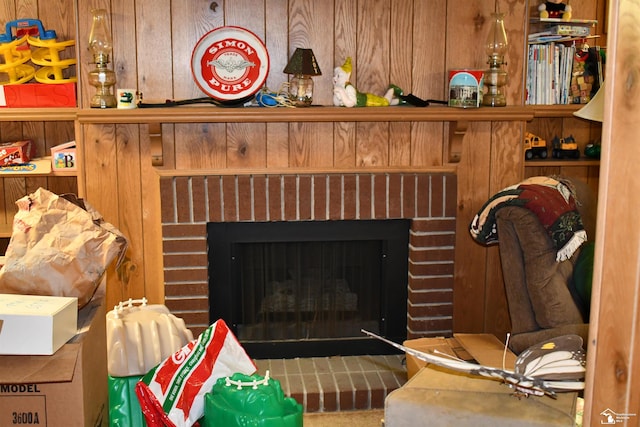 interior details featuring wooden walls and a brick fireplace