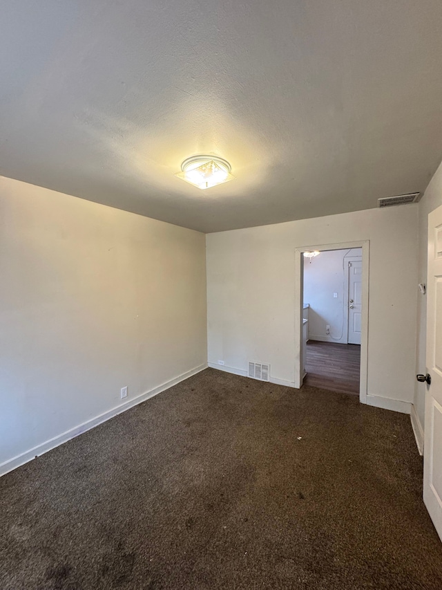 empty room featuring baseboards, visible vents, and carpet