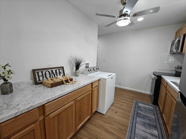 laundry area with washer / dryer, light wood-style flooring, baseboards, and ceiling fan