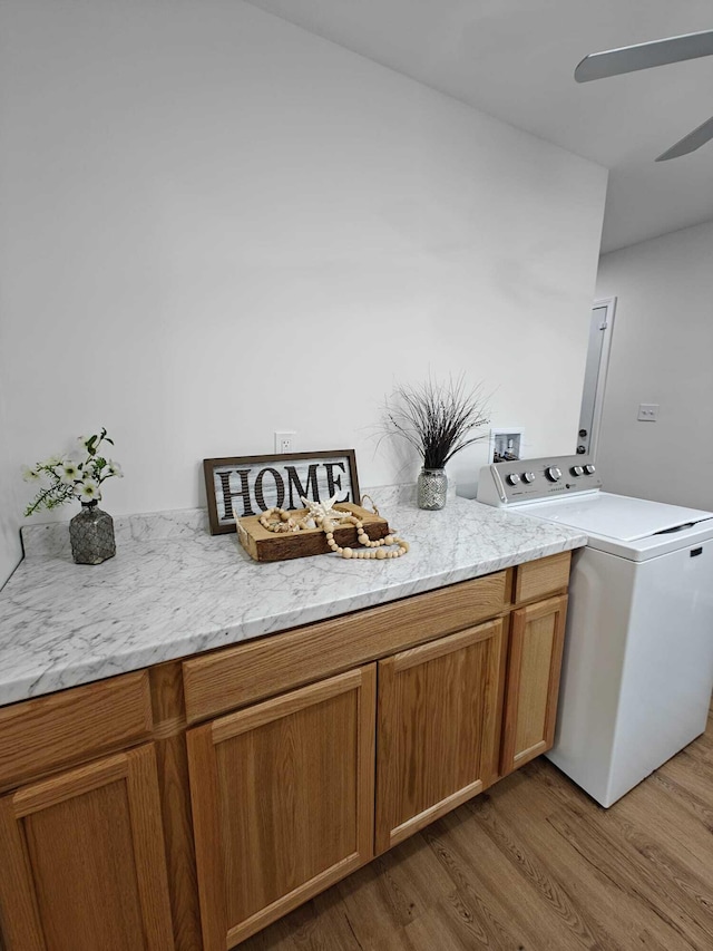 laundry area with washer / clothes dryer, cabinet space, a ceiling fan, and wood finished floors