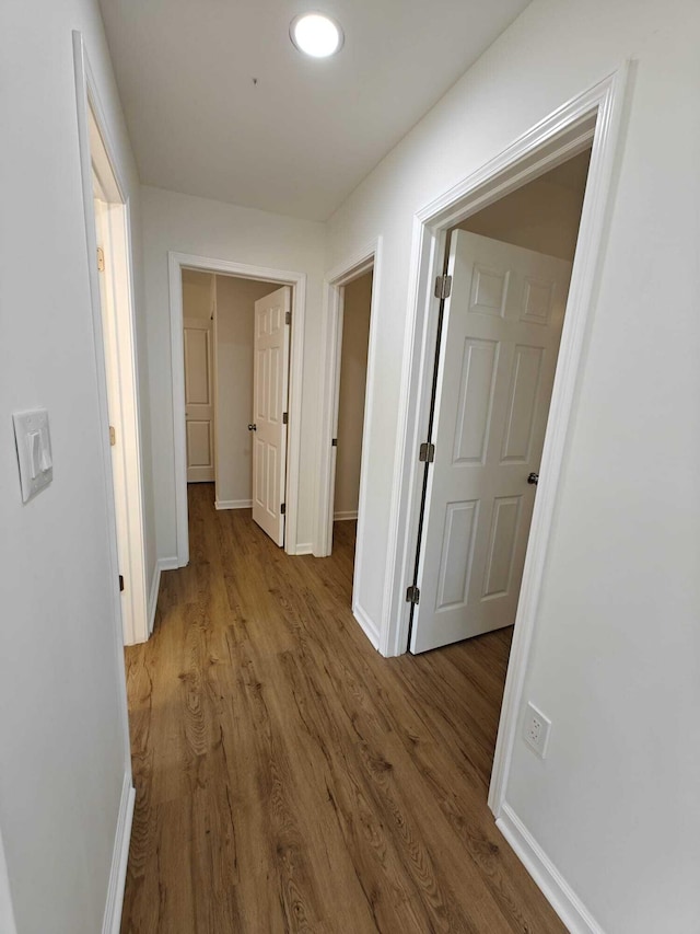 hall featuring wood finished floors and baseboards