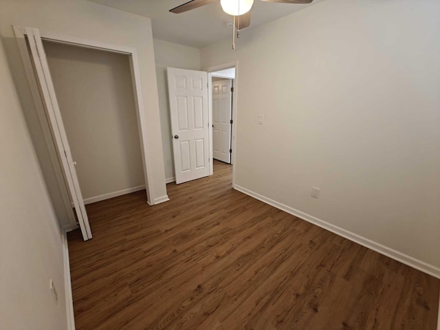 unfurnished bedroom with baseboards, a ceiling fan, and dark wood-type flooring