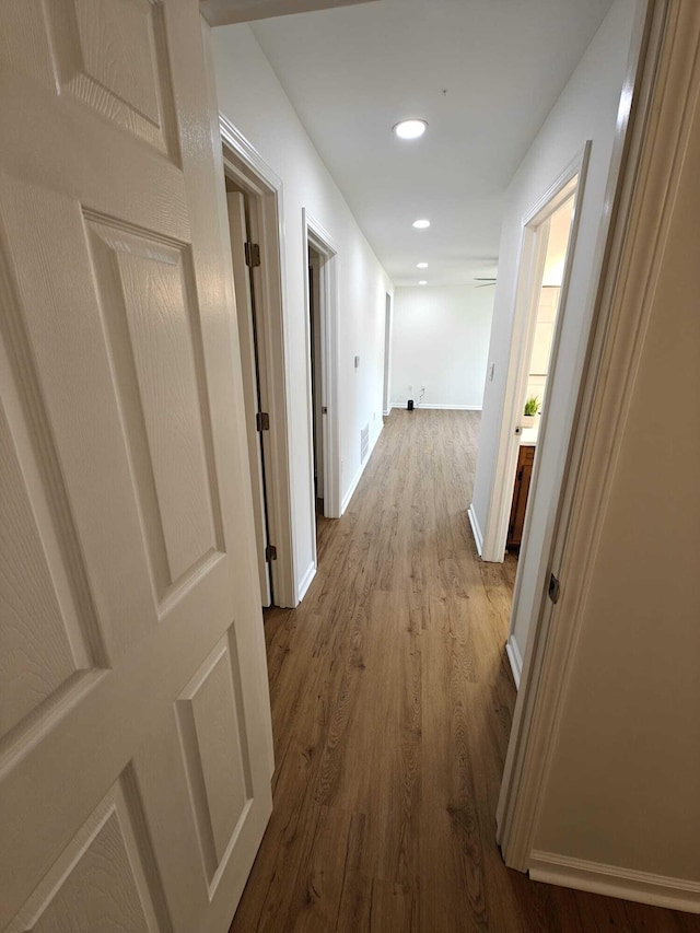 hallway featuring recessed lighting, baseboards, and dark wood-style floors