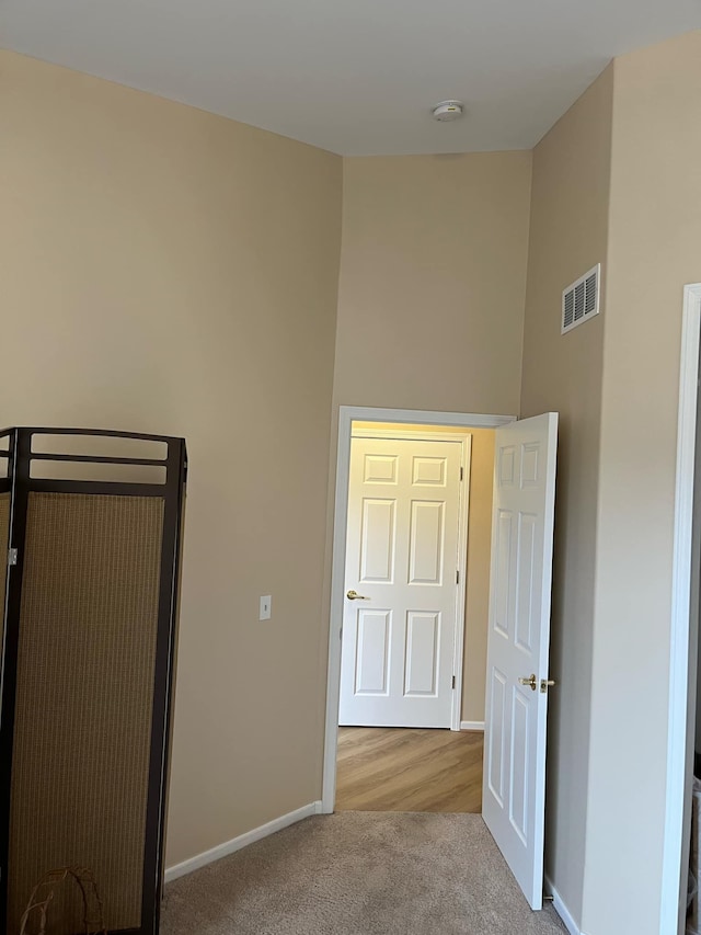 28848 5 Mile Rd Unit 11, Livonia, MI 48154 - unfurnished bedroom with baseboards, carpet flooring, visible vents, and a high ceiling