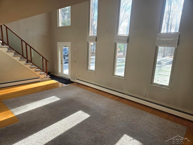 8570 Hornbeam Ln, Saginaw, MI 48603 - entrance foyer with stairway, wood finished floors, a baseboard radiator, and a high ceiling