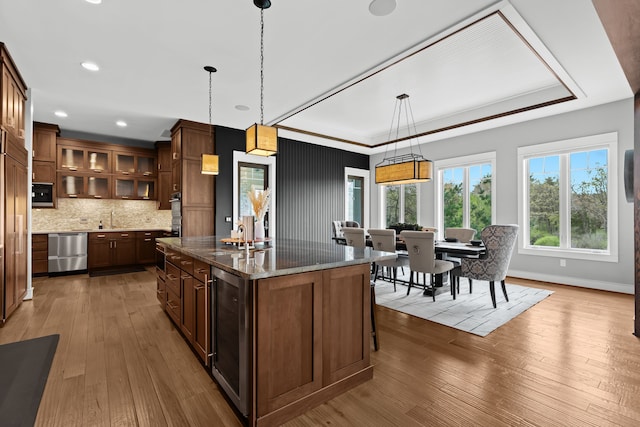 5744 Wyndam Ln, Brighton, MI 48116 - kitchen featuring a center island, glass insert cabinets, beverage cooler, dishwasher, and hardwood / wood-style floors