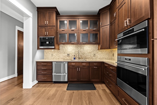 5744 Wyndam Ln, Brighton, MI 48116 - kitchen with light wood-style flooring, baseboards, light countertops, and decorative backsplash
