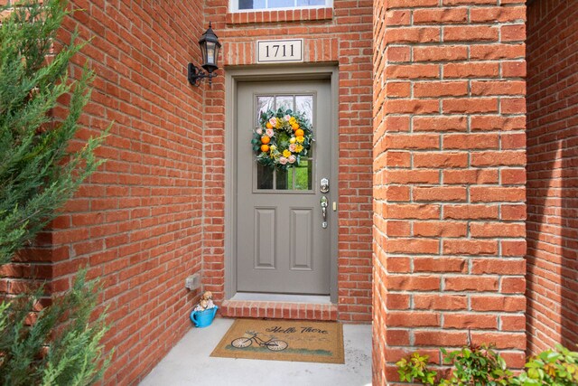 doorway to property with brick siding