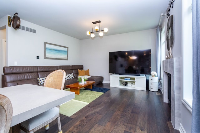 living room with baseboards, dark wood-style flooring, visible vents, and a large fireplace