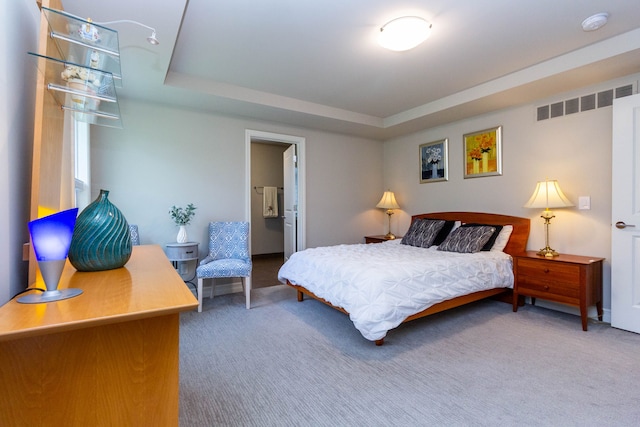 carpeted bedroom with a raised ceiling and visible vents