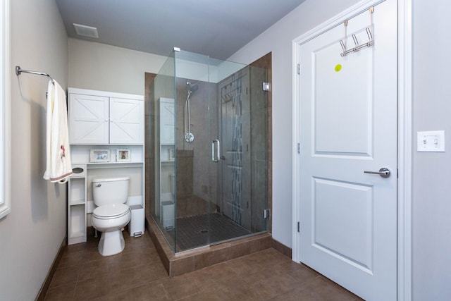 bathroom featuring toilet, baseboards, visible vents, and a shower stall