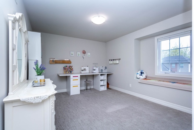 carpeted home office featuring built in study area and baseboards