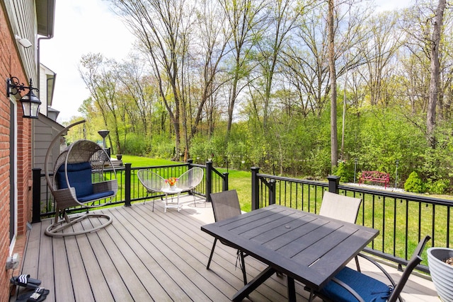 deck with a yard and outdoor dining space