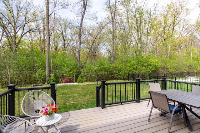 wooden deck featuring a yard, outdoor dining space, and fence
