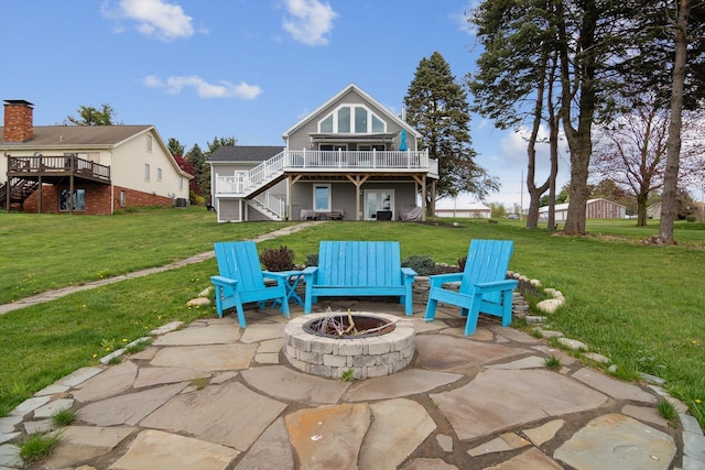 back of house with stairs, a deck, a yard, a patio, and an outdoor fire pit
