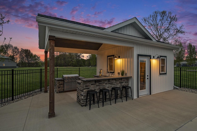 view of patio featuring fence, area for grilling, and outdoor dry bar