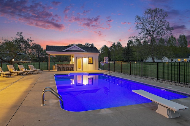 view of pool featuring fence, a patio area, outdoor dry bar, an outbuilding, and a fenced in pool