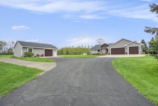 view of front of property featuring a front yard, an attached garage, and driveway