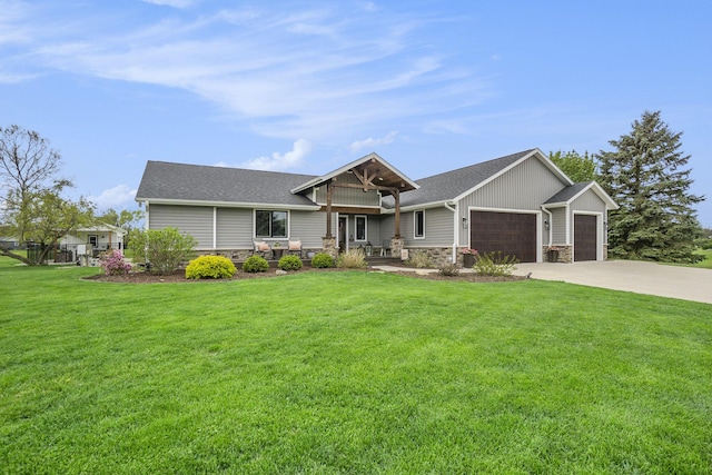 view of front facade featuring stone siding, concrete driveway, a garage, and a front lawn