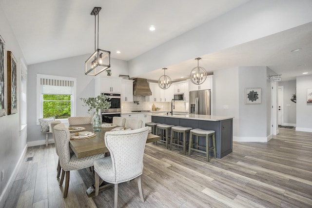 dining space featuring baseboards, an inviting chandelier, recessed lighting, and light wood-style flooring