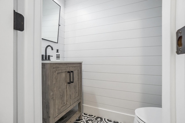 half bath featuring vanity and toilet