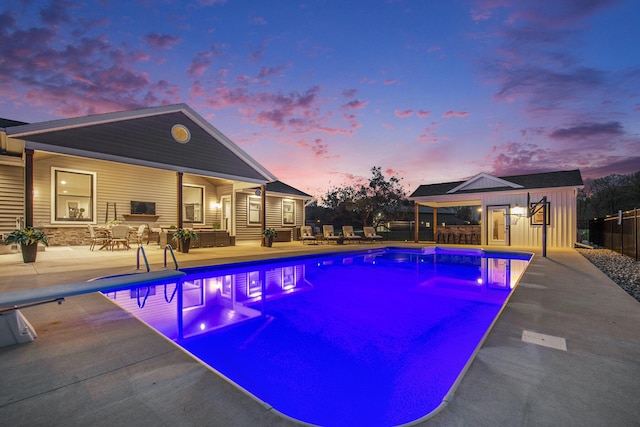 pool at dusk with a patio, a diving board, fence, an outdoor hangout area, and a fenced in pool